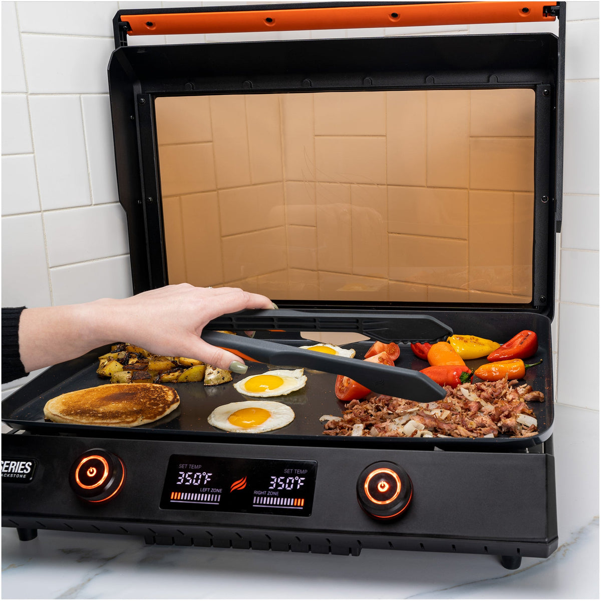 Blackstone E-Series 4 Piece Nylon Griddle Kit - tongs in use