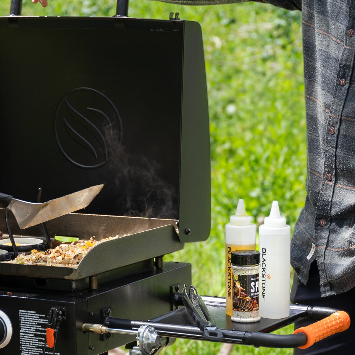 Blackstone On The Go 22" Omnivore Gas Griddle with Hood and Flexfold Legs - Black - cooking a stir fry