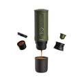 Outin Nano portable espresso machine in Forest Green with ground coffee, coffee capsules and a glass of espresso