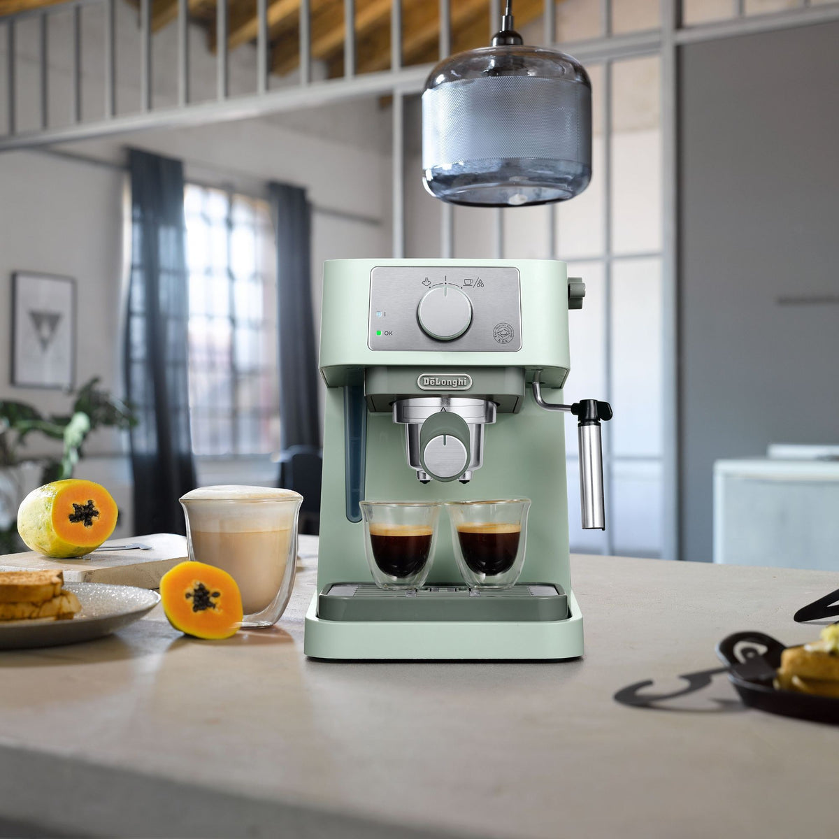 De'Longhi Stilosa Espresso Maker - Green - on a kitchen counter with breakfast