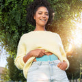 Beurer EM 55 Menstrual Relax+ pad held against the abdomen — lifestyle view