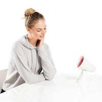 Beurer IL 21 Infrared Lamp 150W, lifestyle shot with model at table