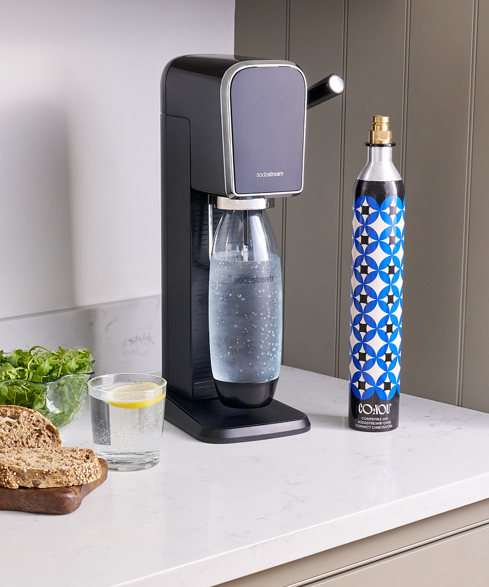 CO2U Quick Click CO2 Cylinder - beside a sparkling water machine