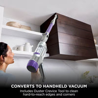 Shark PowerDetect Cordless Vacuum Cleaner converted to handheld mode with Duster Crevice Tool, cleaning the top of a cabinet, captioned 'Converts to handheld vacuum'