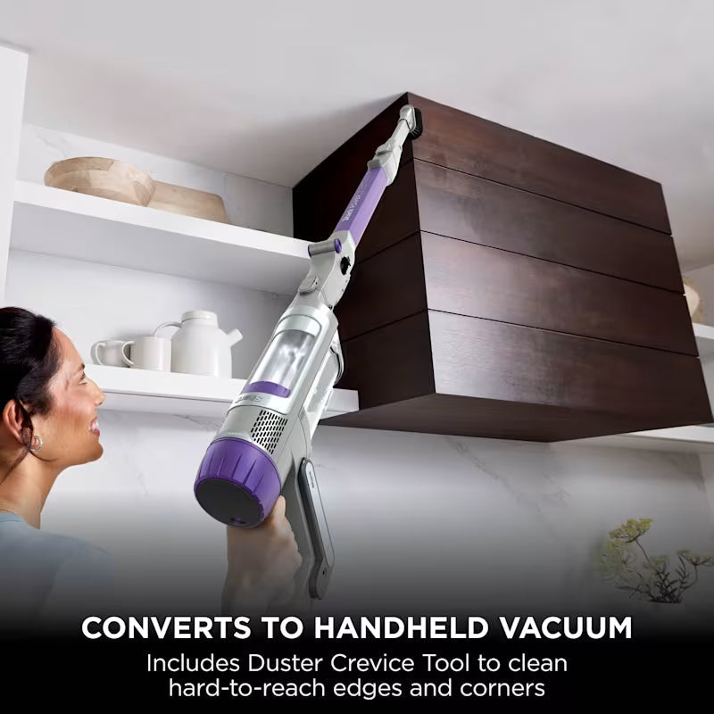 Shark PowerDetect Cordless Vacuum Cleaner converted to handheld mode with Duster Crevice Tool, cleaning the top of a cabinet, captioned 'Converts to handheld vacuum'