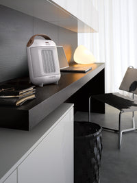 De'Longhi Capsule 1800W Fan Heater - White - beside a home office desk