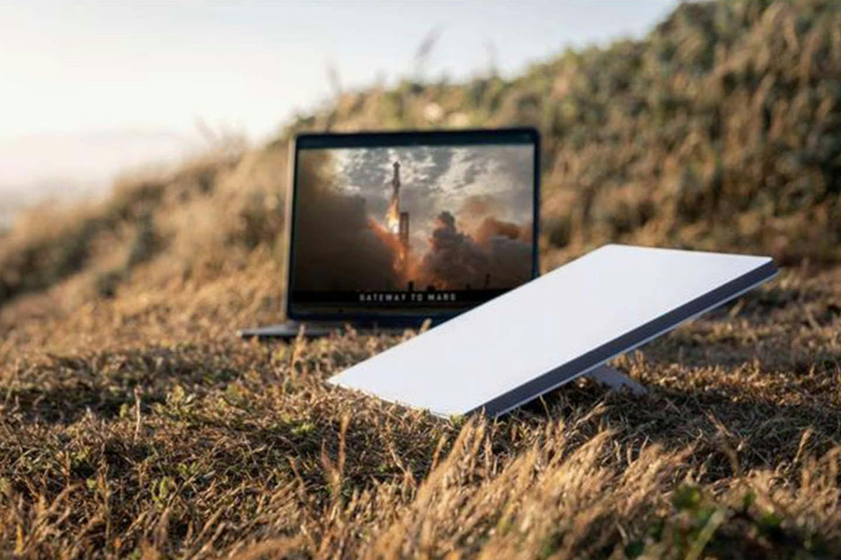 Starlink Mini Satellite Antenna & WiFi Router Kit - White - with a laptop outdoors