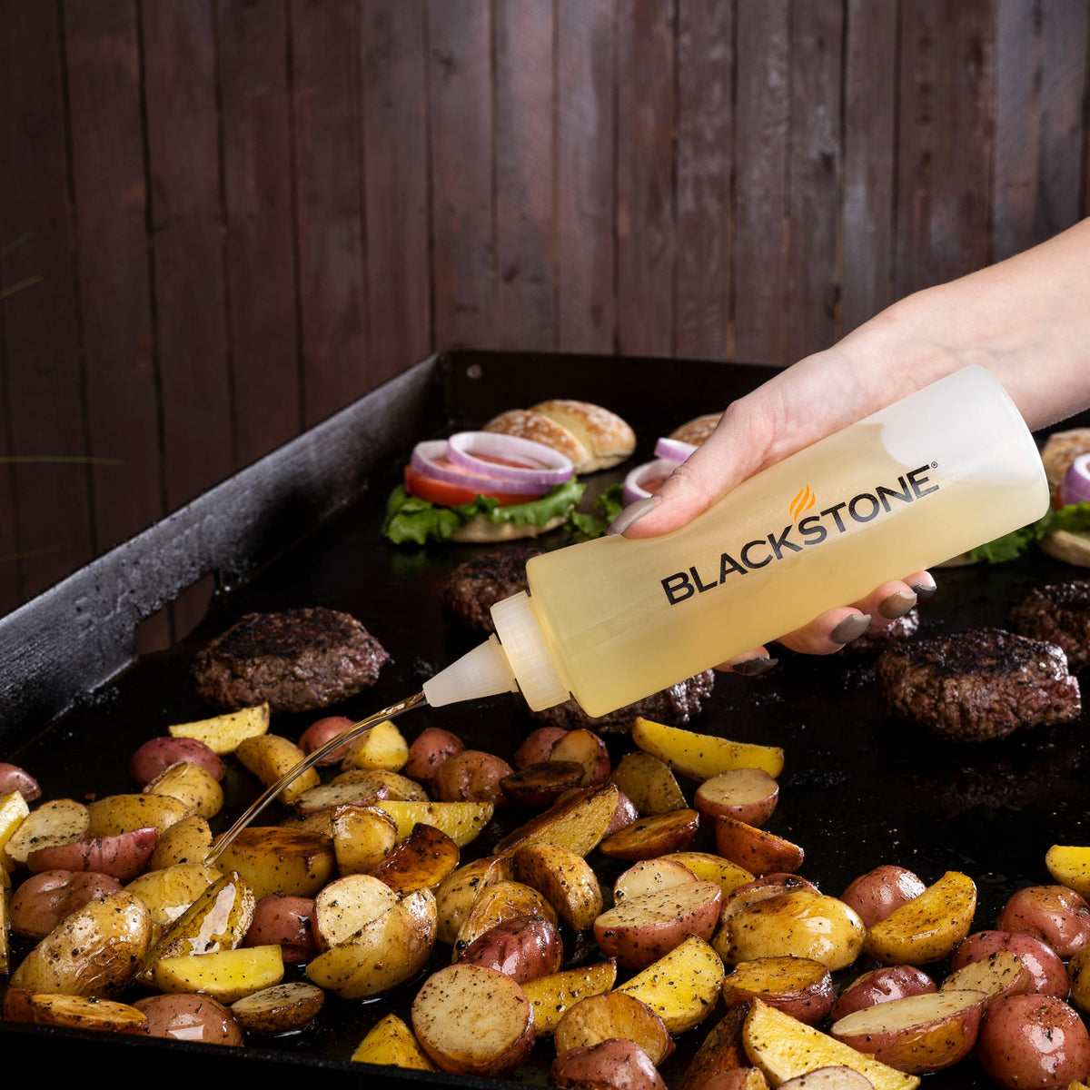 Blackstone 5 Piece Griddle Toolkit - squeezing oil onto the plate