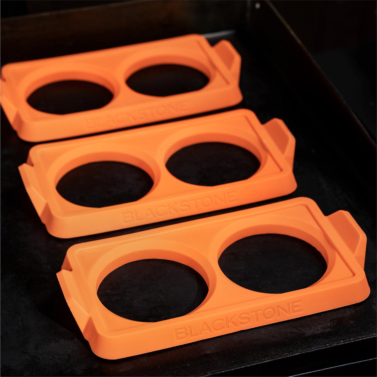 Blackstone 2 Section Silicone Egg Ring Trays, 3 Pack - Orange - empty trays on the griddle