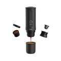 Outin Nano portable espresso machine in Space Grey with ground coffee, coffee capsules and a glass of espresso