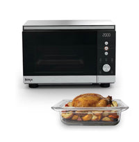 Ninja CRISPi microwave, air fryer and oven in Silver on white background, with roast chicken dish