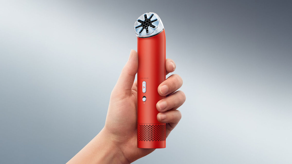 Dyson HushJet Mini Cool Portable Fan - Carnelian/Sky - held in the hand