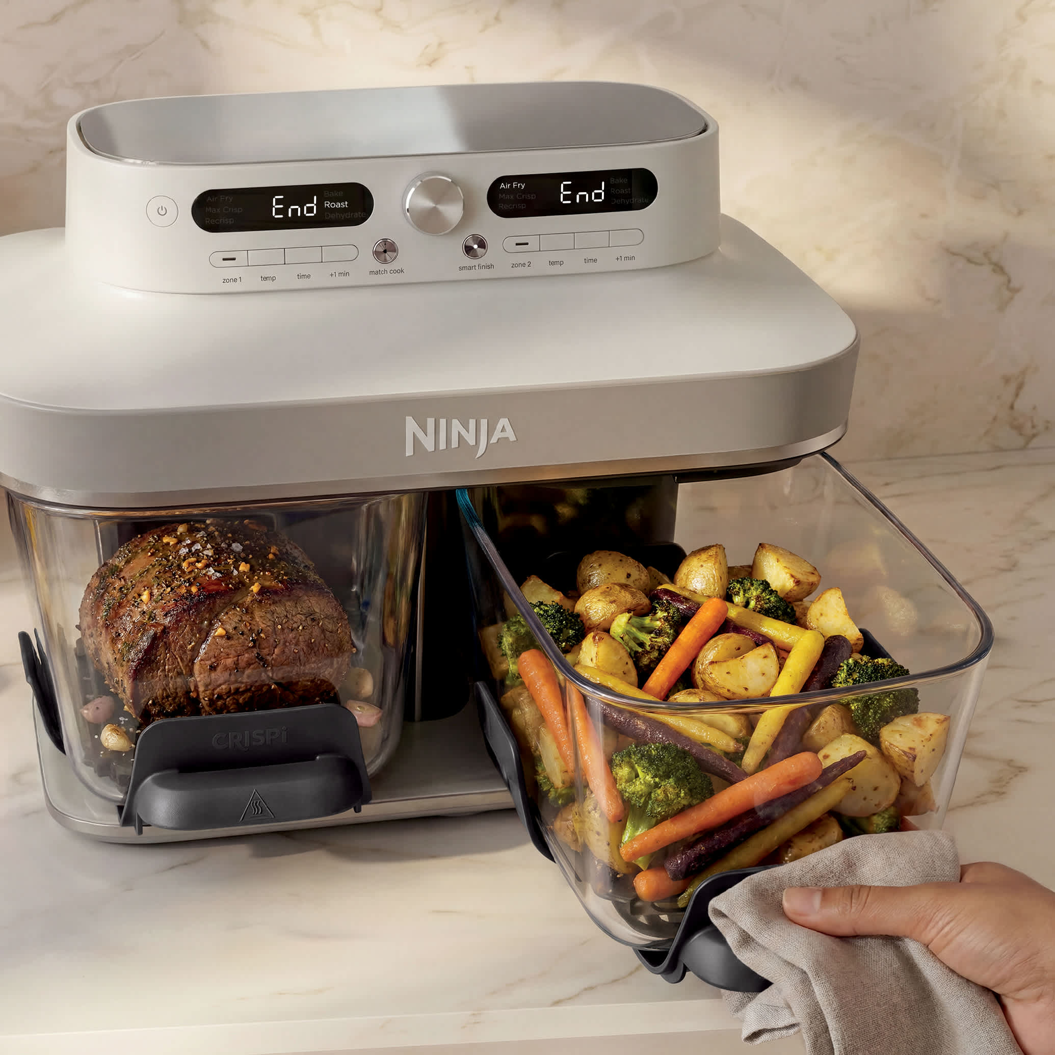 Ninja Crispi DualZone Glass Air Fryer in Bone on marble counter, door zones visible