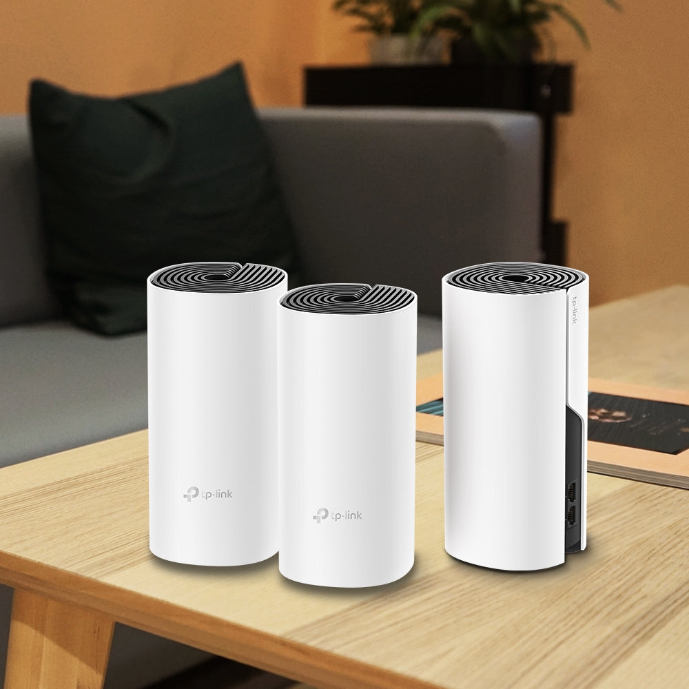 TP-Link Deco M4, three units on a wood table — lifestyle