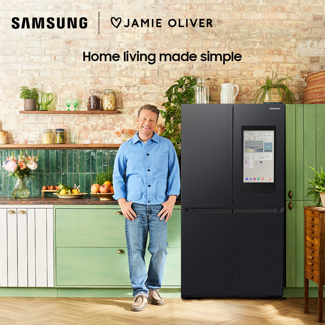 Samsung Family Hub RF65DG9H0EB1EU fridge freezer in a kitchen with a man standing beside it