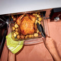 Ninja CRISPi microwave in Silver, overhead lifestyle shot of hands lifting a roast dinner from the open drawer