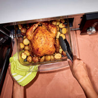 Ninja CRISPi microwave in Silver, overhead lifestyle shot of hands lifting a roast dinner from the open drawer