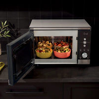 Ninja CRISPi microwave in Silver, door open on dark kitchen counter with bowls of food inside