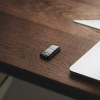 TP-Link TL-WN823N N300 Mini Wi-Fi USB Adapter, QSS button — desk flat-lay view, alternate angle