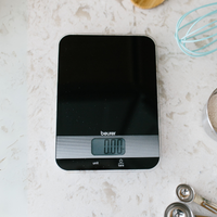 Beurer KS 19 Kitchen Scale Black, top-down view on kitchen counter with measuring spoons