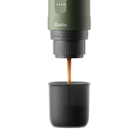 Outin Nano portable espresso machine in Forest Green with ground coffee, coffee capsules and a glass of espresso