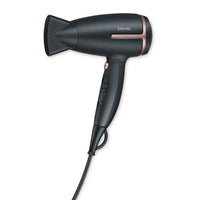 Beurer HC 25 Travel Hair Dryer with Ion, studio shot showing black and rose-gold folding dryer