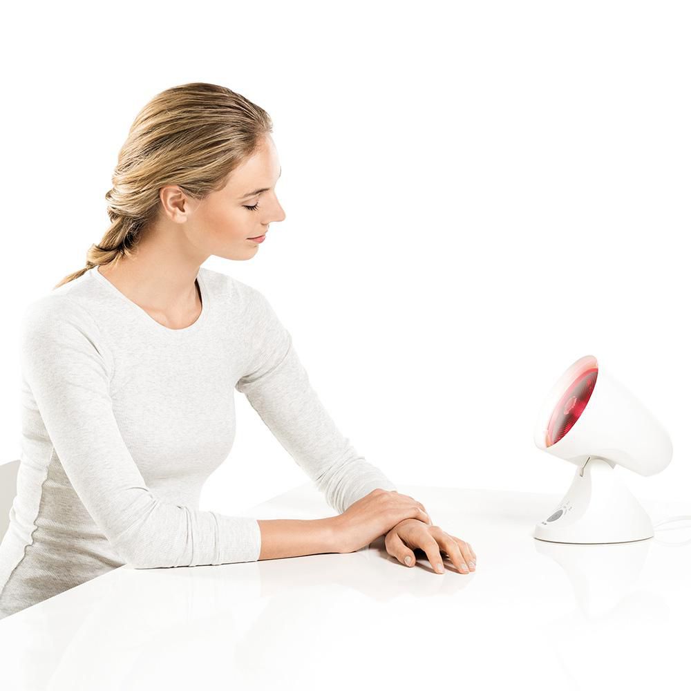 Beurer IL 35 Infrared Lamp 150W with Timer, lifestyle shot with model at table