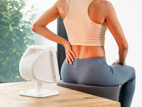 Beurer IL 60 Infrared Lamp in use on lower back, white rectangular panel visible