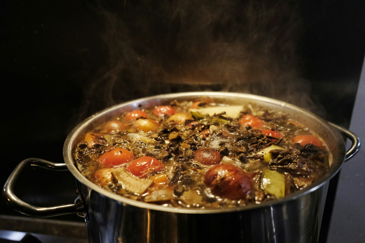 Pot of vegetable stock simmering on a stove