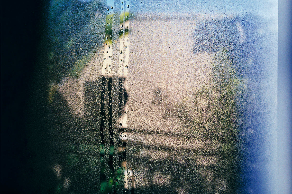 Condensation on the inside of a window, with drips running down the glass