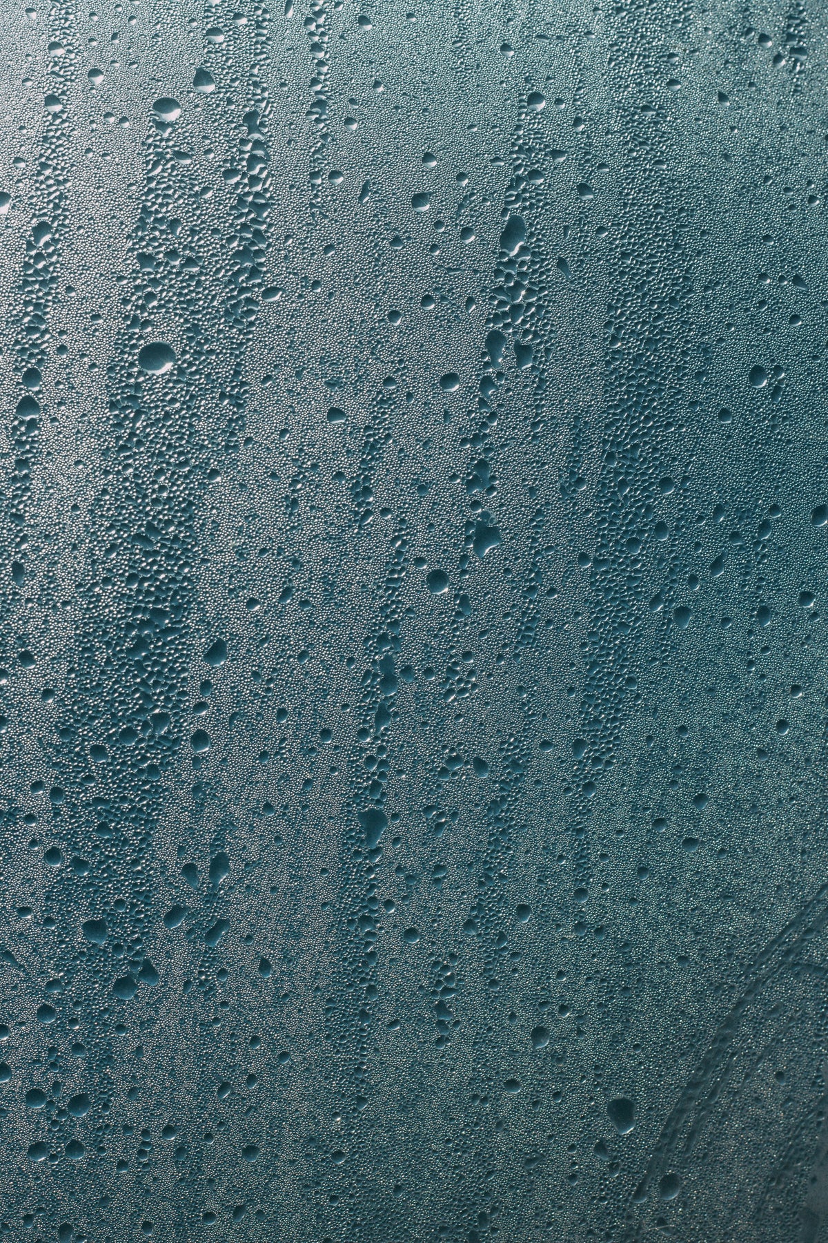 Condensation droplets running down a pane of glass